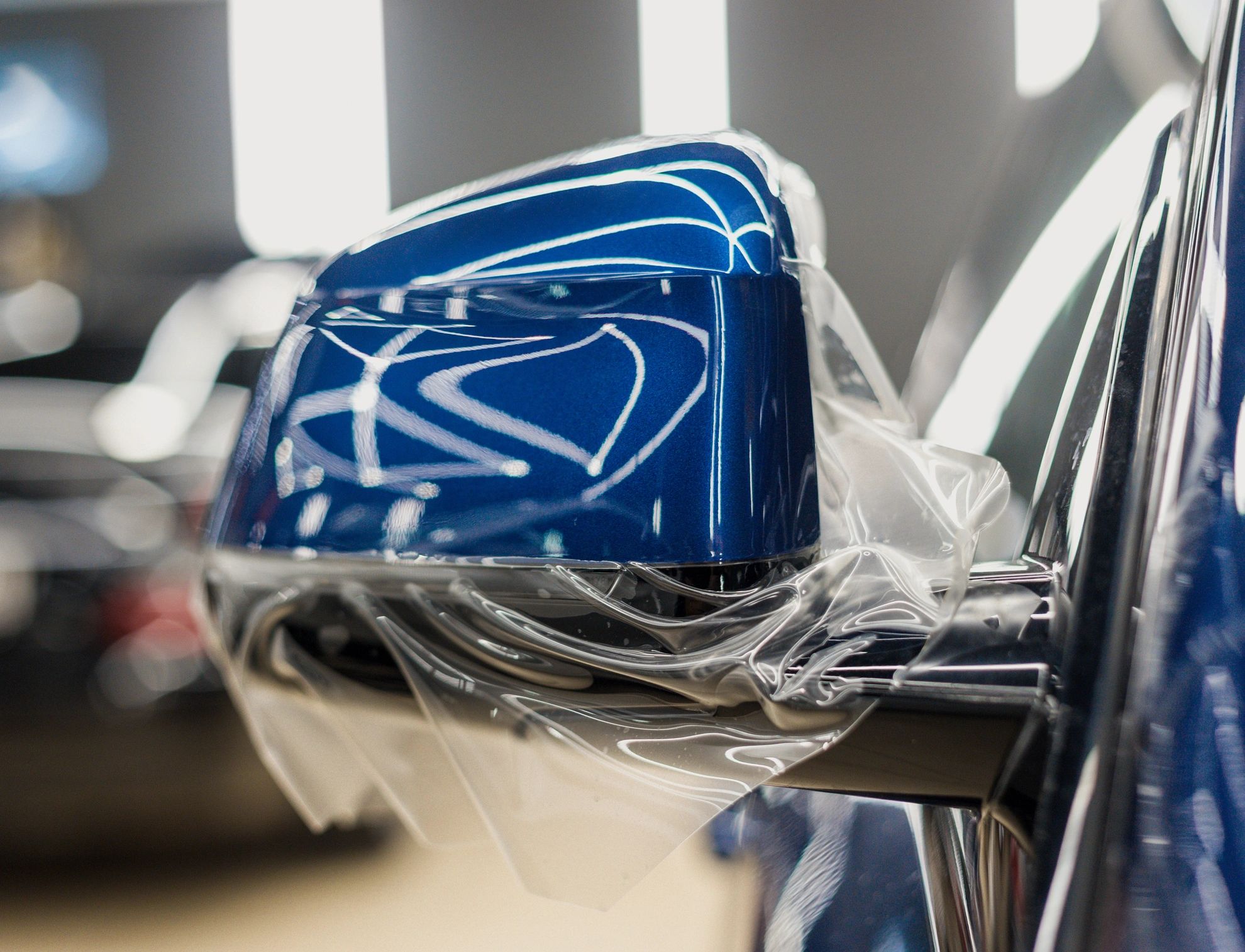 Paint protection film being installed on a car side mirror